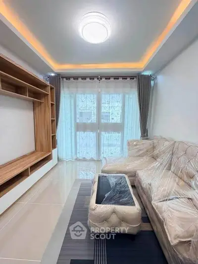Modern living room with elegant furniture and large window, perfect for relaxation and entertainment.