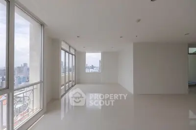 Spacious empty apartment with large windows offering stunning city views, perfect for customization.