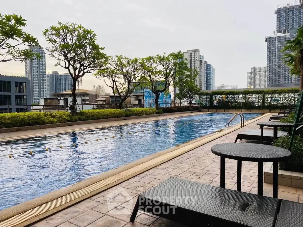 Luxurious rooftop pool with city skyline views and lush greenery, perfect for relaxation and leisure.