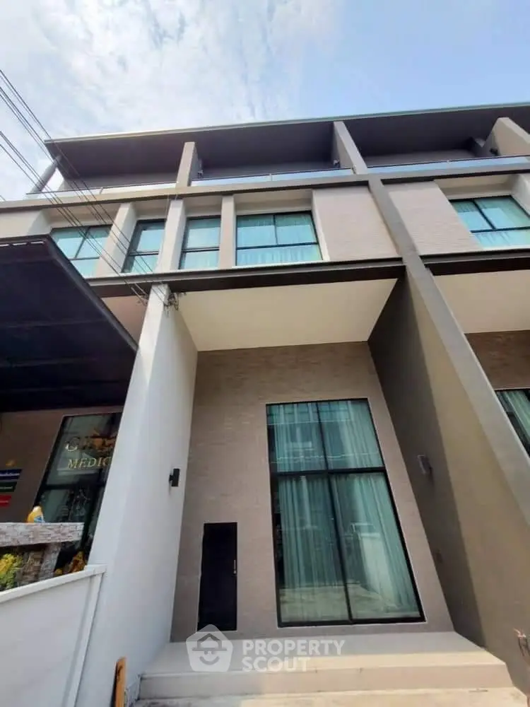 Modern multi-story building exterior with large windows and sleek design.