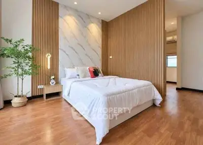 Elegant bedroom with modern design and wooden accents, featuring a cozy bed and stylish decor.