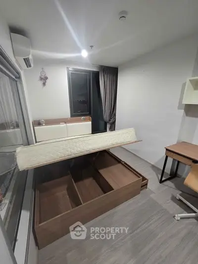 Modern bedroom with storage bed and desk, featuring sleek design and ample natural light.