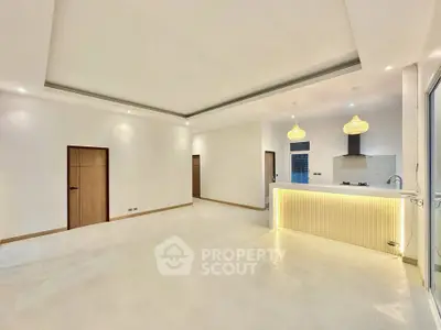 Spacious modern living room with open kitchen and elegant lighting