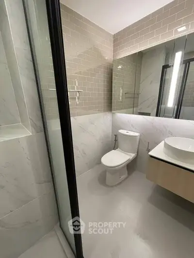 Modern bathroom with sleek design, featuring a glass shower and stylish vanity.