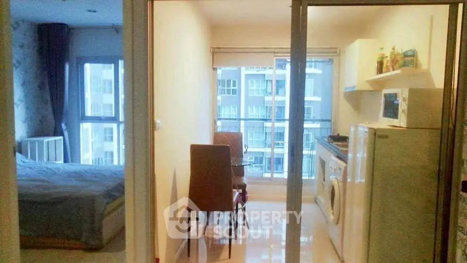 Cozy apartment with bedroom and kitchen featuring modern appliances and city view.
