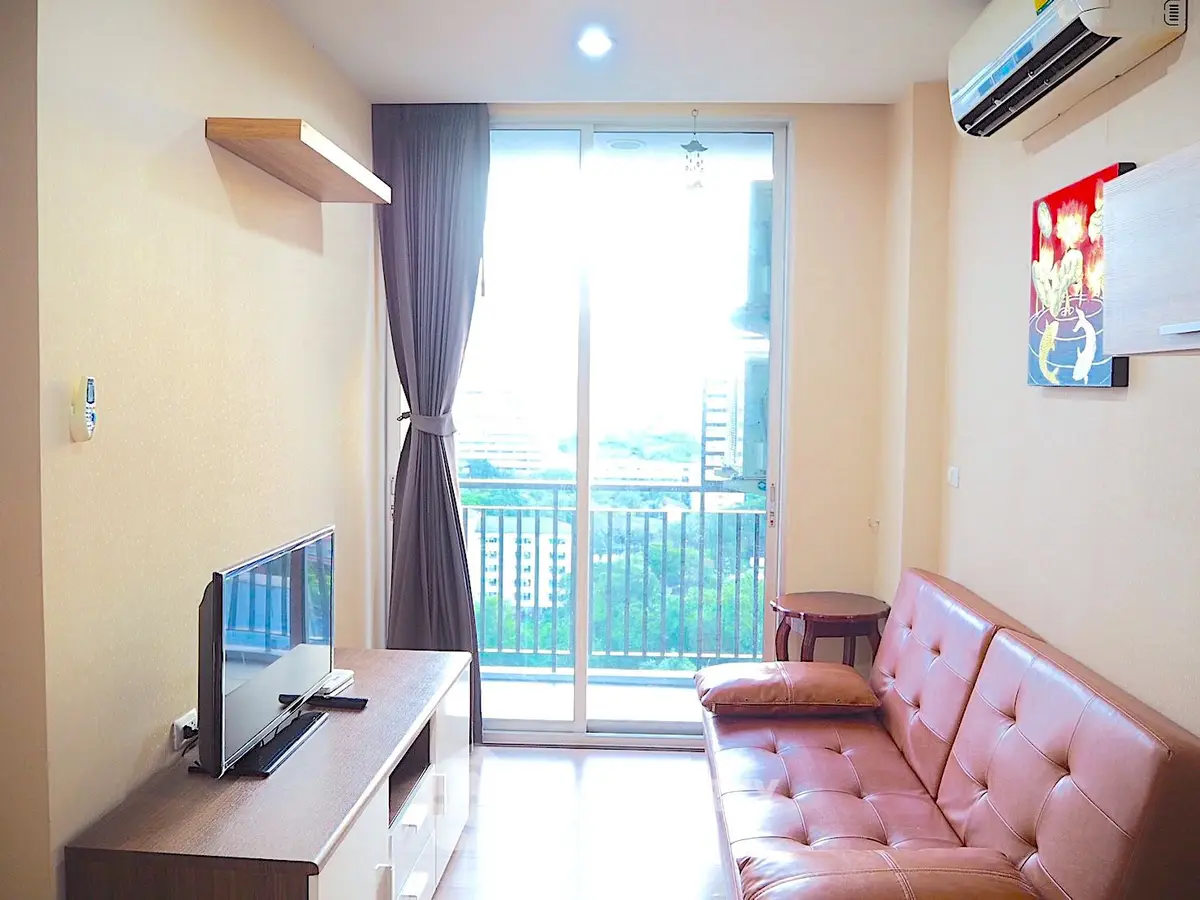 Modern living room with balcony view, featuring sleek furniture and abundant natural light.