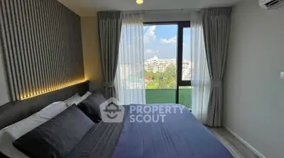 Modern bedroom with large window offering stunning city view and elegant decor.