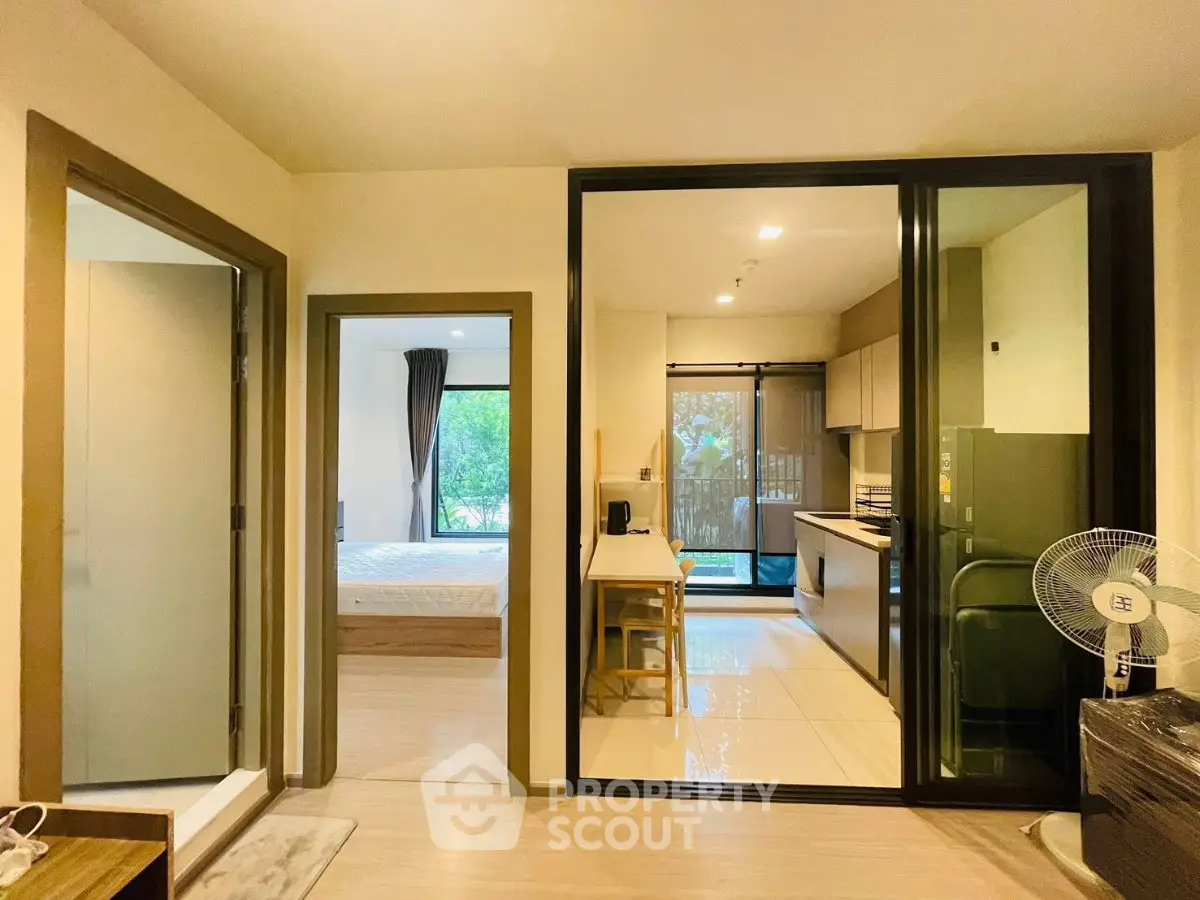 Modern apartment interior with open kitchen and cozy bedroom, featuring sleek design and natural light.