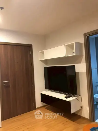 Modern living room with wall-mounted TV and stylish wooden flooring