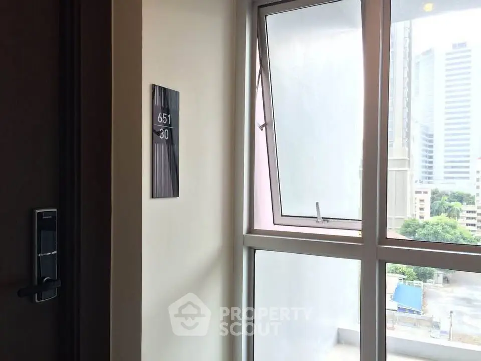 Modern apartment corridor with electronic door lock and city view window