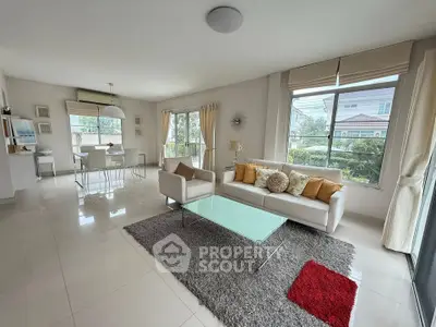 Spacious modern living room with elegant decor and large windows offering garden views.