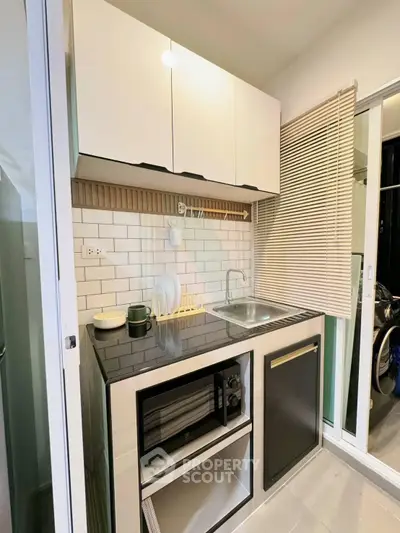 Modern compact kitchen with sleek cabinetry and built-in appliances, perfect for urban living.