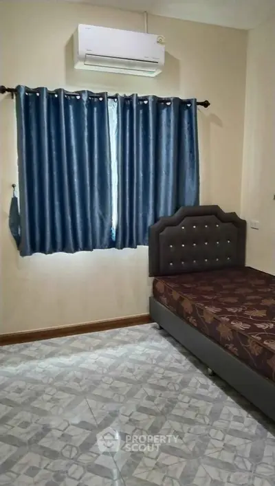 Cozy bedroom with air conditioning and elegant blue curtains, perfect for restful nights.