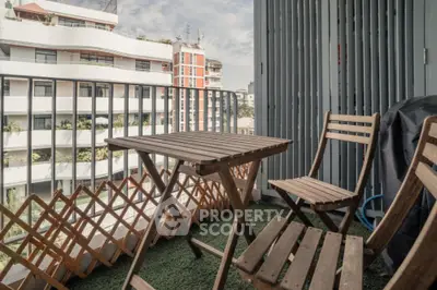 Charming balcony with wooden furniture and city view, perfect for relaxation.