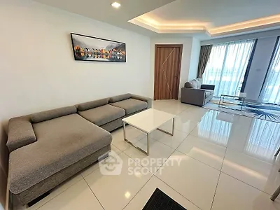 Spacious modern living room with elegant furniture and large windows offering natural light.