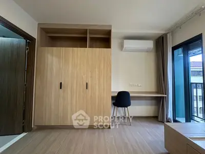 Modern bedroom with built-in wardrobe, desk, and balcony access.
