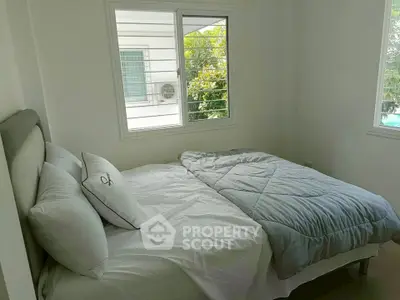 Cozy bedroom with natural light and modern decor, perfect for relaxation.