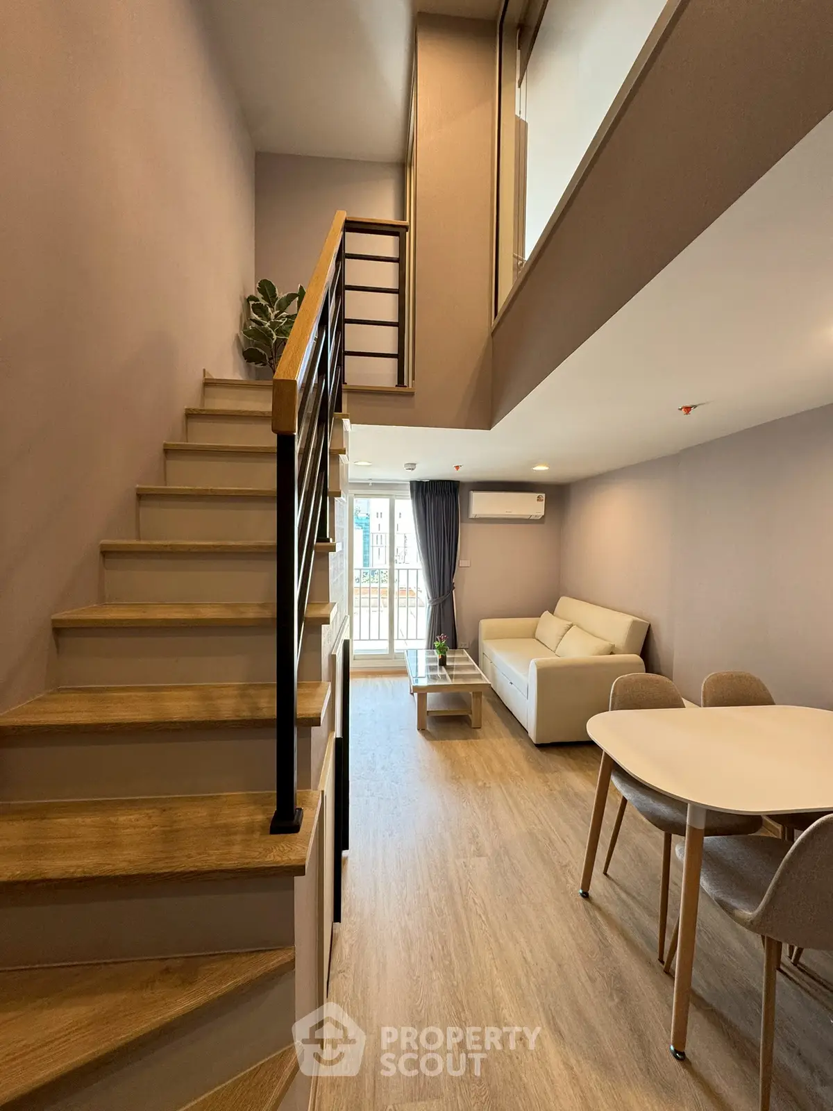 Modern duplex living room with stylish staircase and cozy seating area