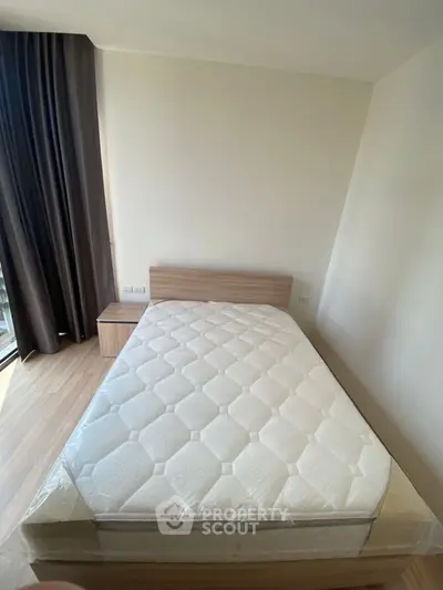 Modern bedroom with new mattress and wooden flooring