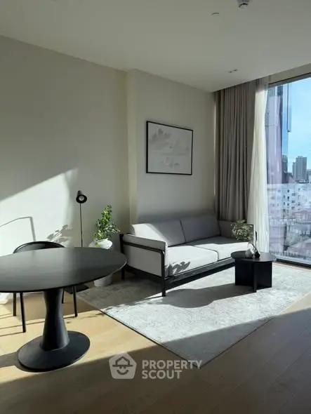 Modern living room with large windows and stylish furniture in a high-rise apartment.