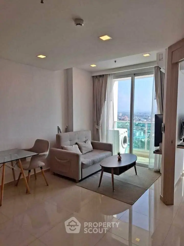 Modern living room with glass doors leading to balcony and city view