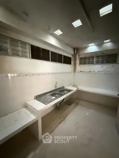 Spacious kitchen with ample counter space and natural light, ideal for culinary enthusiasts.