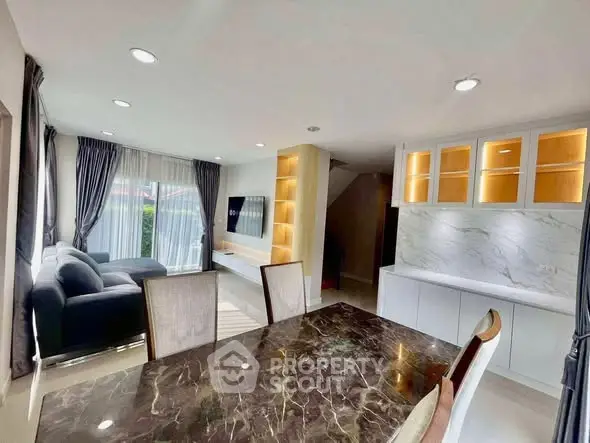 Spacious modern living room with elegant marble dining table and cozy seating area, perfect for entertaining.