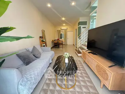 Modern living room with stylish furniture and large TV, perfect for relaxation.