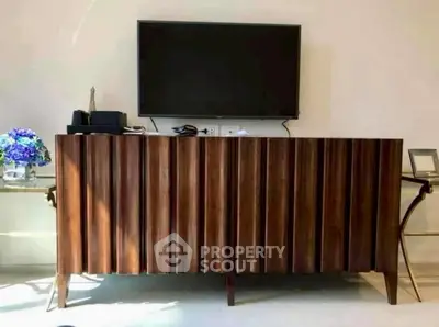 Stylish modern living room with elegant wooden TV stand and wall-mounted flat screen.