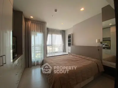 Modern bedroom with large windows and stylish decor in a contemporary apartment.