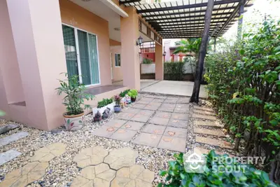 Charming garden patio with potted plants and stone pathway in a serene residential setting.