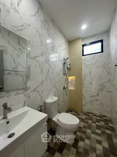 Modern bathroom with marble walls and sleek fixtures in a contemporary home.