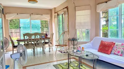 Bright and airy living room with large windows and cozy seating area.