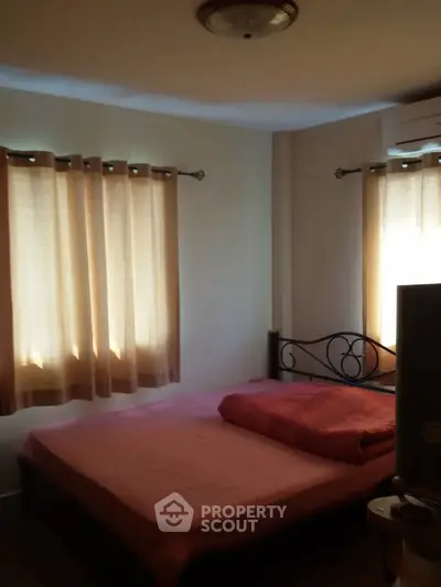 Cozy bedroom with natural light and simple decor, perfect for relaxation.