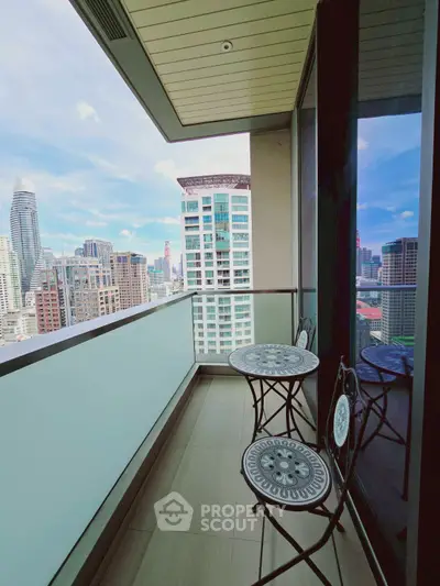 Stunning city view from modern high-rise balcony with stylish furniture.