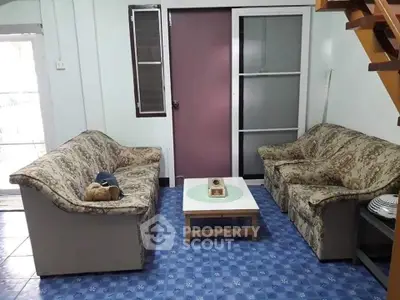 Cozy living room with floral sofas and blue tiled floor