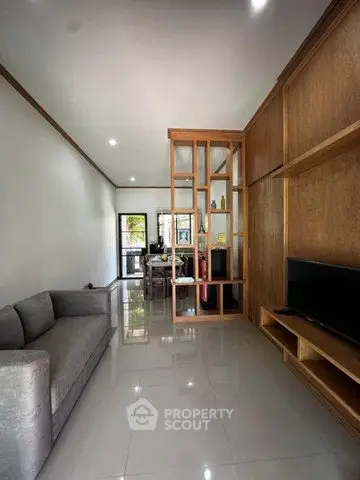 Modern living room with sleek design and open layout, featuring a cozy sofa and stylish shelving.