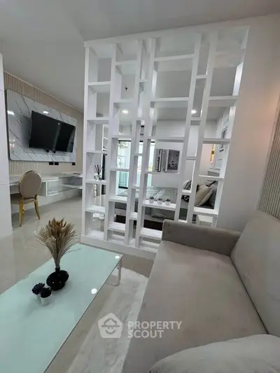 Modern living room with stylish partition, sleek furniture, and wall-mounted TV for contemporary living.