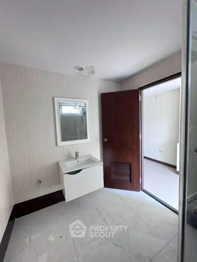 Spacious bathroom with modern sink and elegant tile flooring in a contemporary home.