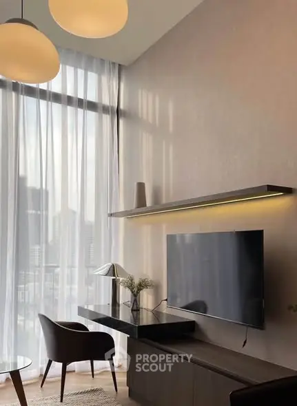 Modern living room with high ceilings, large windows, and stylish furniture in a luxury apartment.