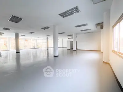 Spacious open-plan commercial space with large windows and ample natural light.
