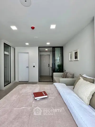 Modern bedroom with stylish decor and cozy ambiance, featuring plush bedding and elegant lighting.