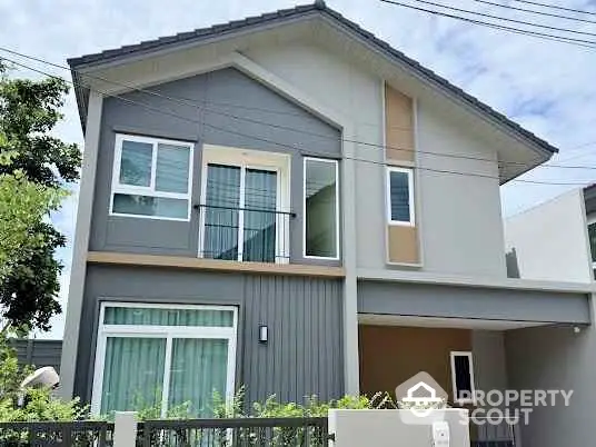 Modern two-story house with large windows and contemporary design.