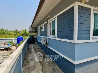 Charming blue exterior house with spacious balcony and lush greenery view.