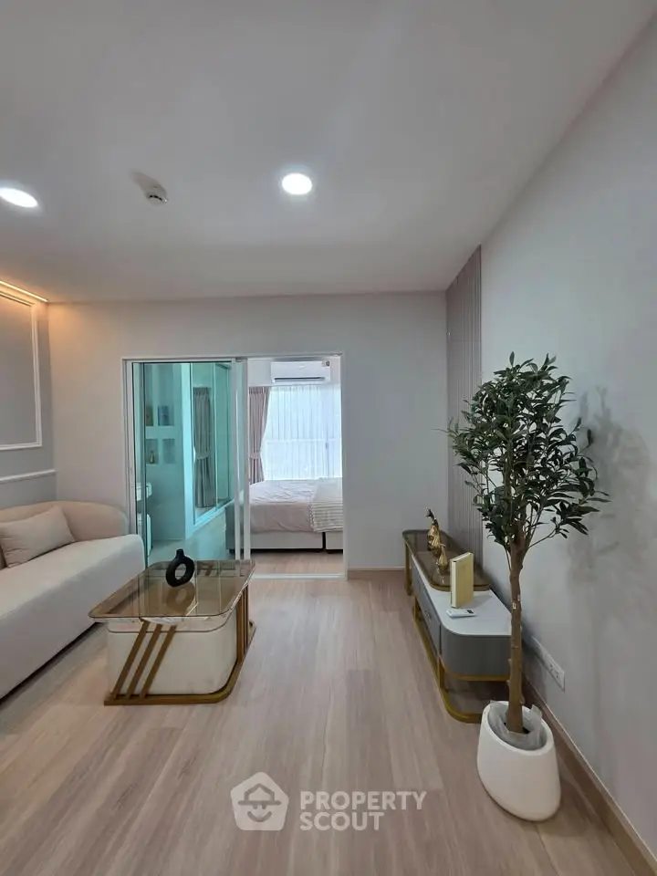 Modern living room with elegant decor and view into a cozy bedroom