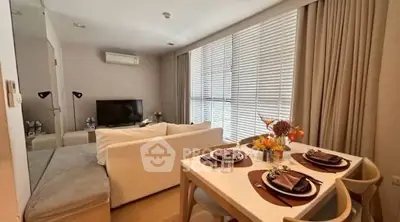 Modern living room with dining area, featuring cozy sofa and elegant table setting, perfect for entertaining.