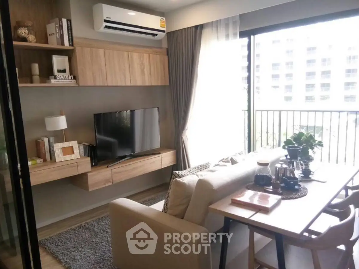 Modern living room with natural light and stylish decor in a high-rise apartment.