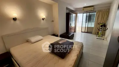 Spacious bedroom with balcony access and exercise equipment, ideal for modern living.
