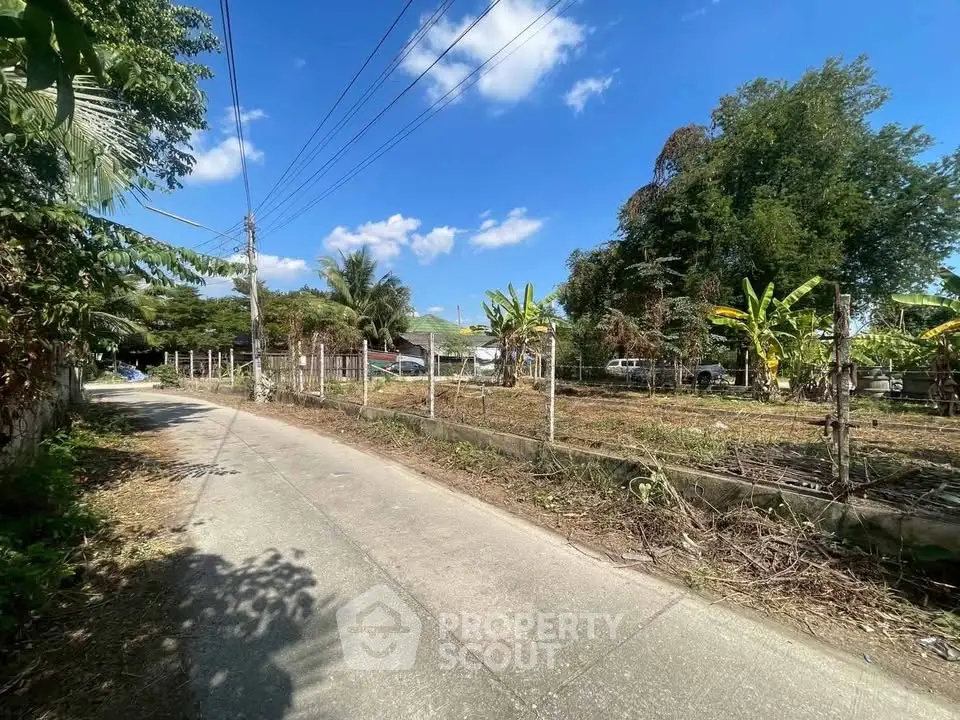 Prime land plot with lush greenery and clear blue sky, ideal for development or investment.
