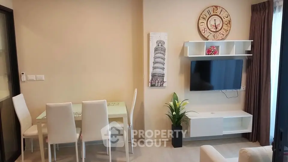 Modern living room with dining area, wall-mounted TV, and stylish decor in a cozy apartment.